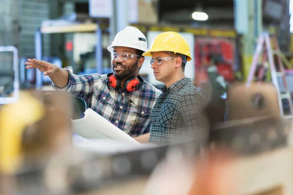 two manufacturing workers discussing plans