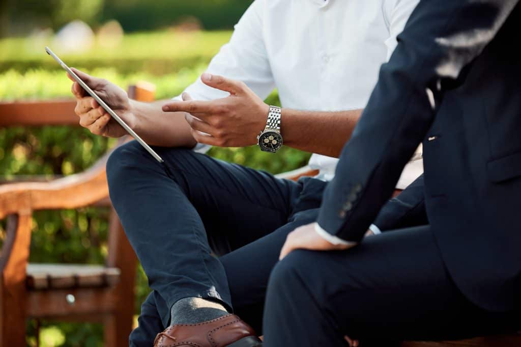 two business people pointing at tablet